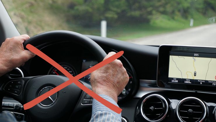 Mani di un anziano al volante