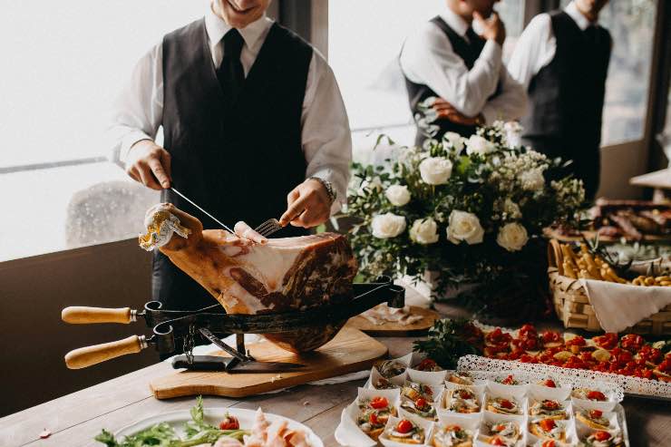 persona che affetta il prosciutto a un matrimonio
