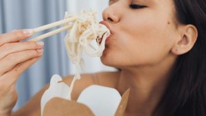 Donna che mangia voracemente degli spaghetti