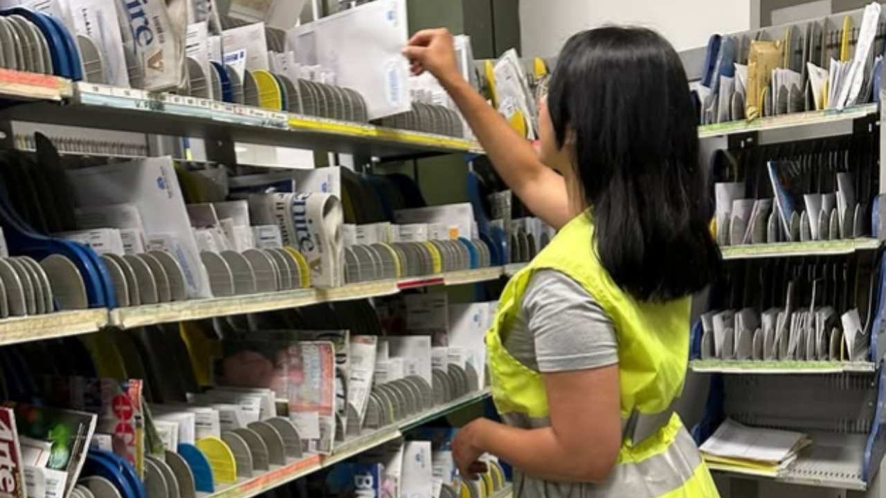 Postina che prende la posta da consegnare